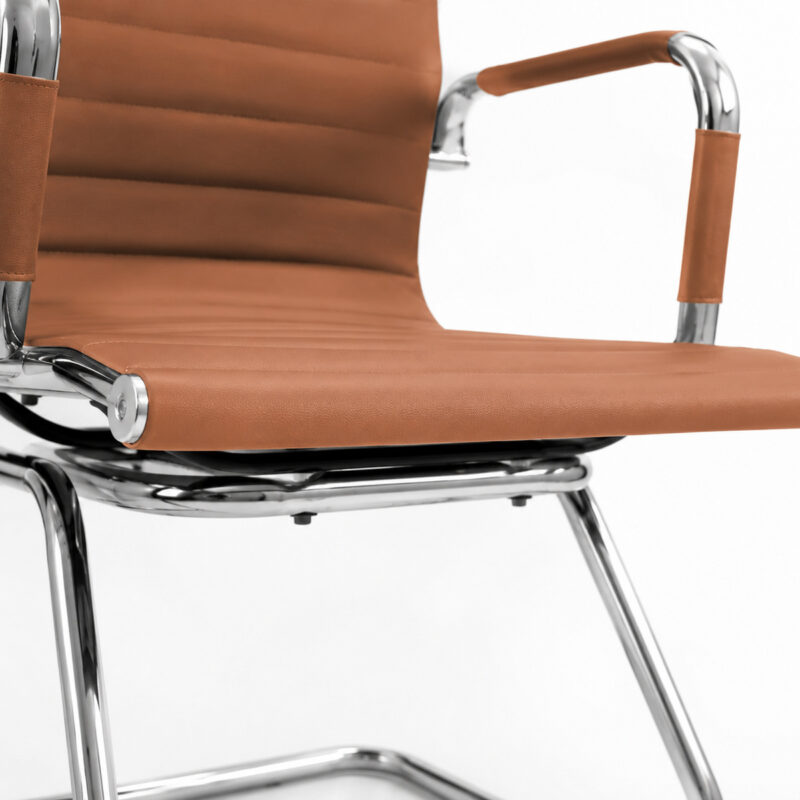 Detalhe da Cadeira Charles Eames Caramelo mostrando revestimento e acabamento metálico cromado em destaque.
