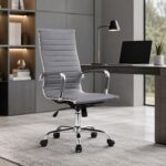Cadeira Presidente Charles Eames Esteirinha cinza posicionada junto a mesa em ambiente de escritório.