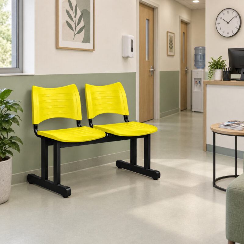Cadeira longarina plástica de 2 lugares amarela utilizada na recepção moderna de uma clínica.