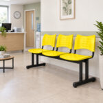Longarina Plástica de 3 Lugares para Clínica Cadeira longarina plástica de 3 lugares amarela utilizada na recepção moderna de uma clínica.