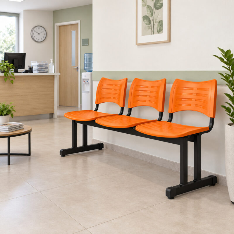 Cadeira longarina plástica de 3 lugares laranja utilizada na recepção moderna de uma clínica.