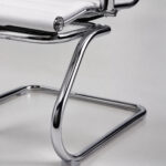 Detalhe da Cadeira Charles Eames Branca mostrando corino branco e acabamento metálico cromado em destaque.