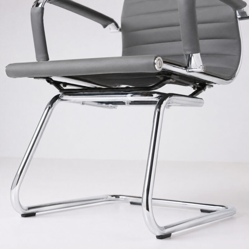 Close inferior da Cadeira Charles Eames cinza mostrando a junção do assento com a base fixa cromada.