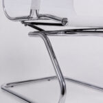 Close inferior da Cadeira Charles Eames Branca mostrando a junção do assento com a base fixa cromada.