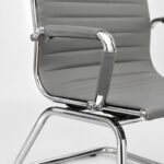 Detalhe de fixação da Cadeira Charles Eames cinza entre assento, braço cromado e estrutura metálica fixa.