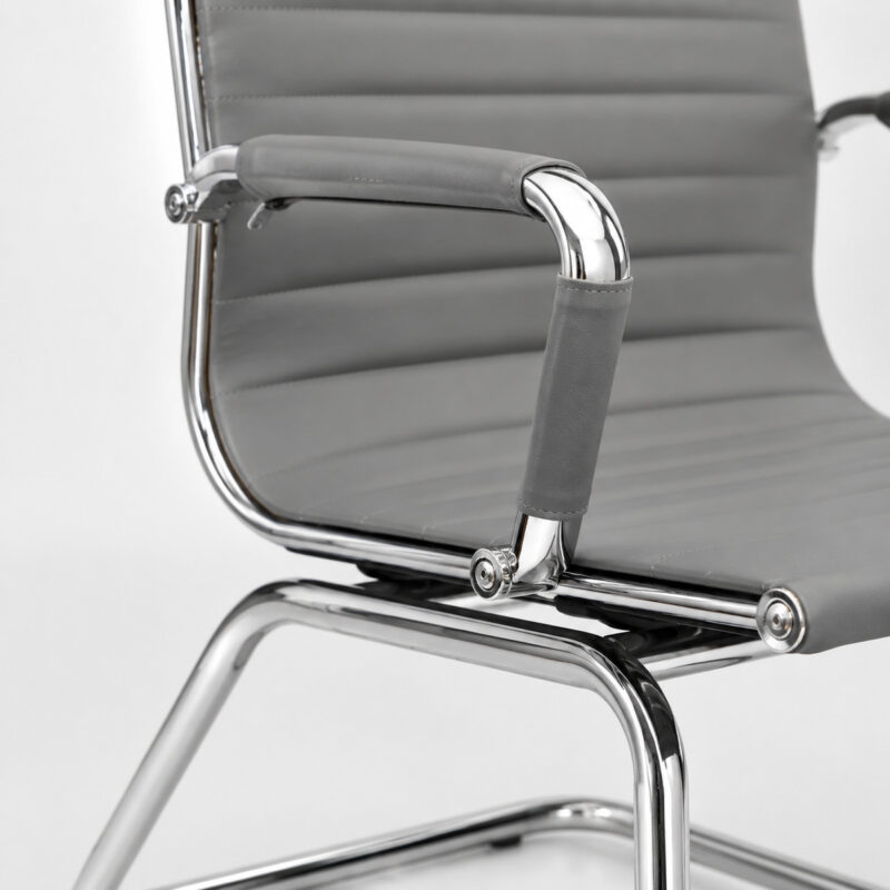 Detalhe de fixação da Cadeira Charles Eames cinza entre assento, braço cromado e estrutura metálica fixa.