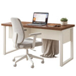 Mesa pé quadro com cadeira clara e notebook Mesa pé quadro com notebook, caderno e vaso, acompanhada de cadeira clara e manta pendendo sob o tampo.