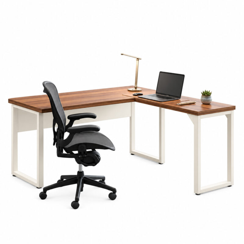 Mesa em L sem gavetas com notebook, luminária e planta, acompanhada de cadeira giratória preta.