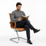 Pessoa adulta sentada na Cadeira Charles Eames Esteirinha Terracota em demonstração de uso do modelo fixo.