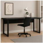 Mesa preta com pé quadro em ambiente de trabalho Mesa preta com cadeira giratória em ambiente com luminária branca, planta, livros e quadro decorativo na parede.