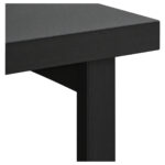 Detalhe do tampo e do apoio da mesa de escritório preta Detalhe da mesa preta mostrando a borda do tampo, o encontro com o apoio vertical e parte do painel inferior.