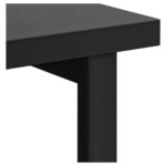 Detalhe do tampo e da estrutura da mesa dupla preta Detalhe da mesa preta mostrando a borda do tampo, o encontro com o apoio vertical e parte do painel inferior.