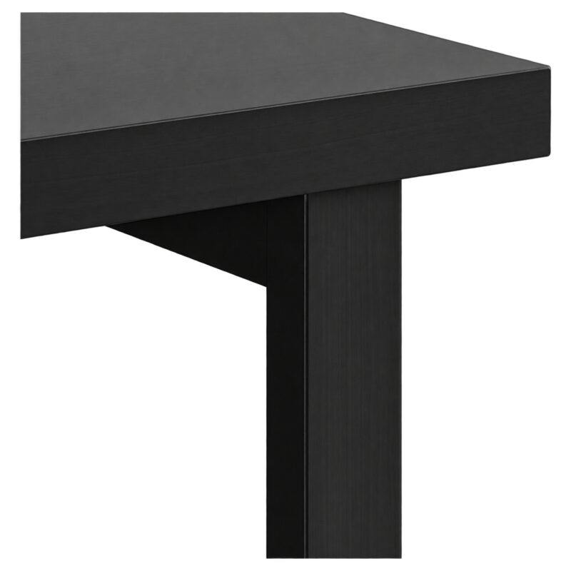 Detalhe da mesa preta mostrando a borda do tampo, o encontro com o apoio vertical e parte do painel inferior.