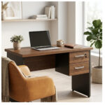 Mesa Louro e Preto para compor seu home office Mesa Louro e Preto com notebook e duas gavetas em espaço com poltrona amarela, plantas e prateleira na parede.