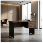 Mesa com duas gavetas em escritório com iluminação natural Mesa louro e preto com duas gavetas fechadas, ambientada junto a grandes janelas, com luminária sobre o tampo.