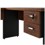 Mesa em L: duas gavetas e fechadura com chave em detalhe Duas gavetas amadeiradas sob o tampo da mesa, com puxadores metálicos e chaves inseridas na fechadura superior.