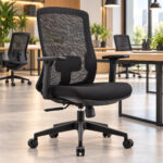 Cadeira giratória em tela preta — em ambiente de trabalho iluminado Cadeira preta com encosto em tela junto a uma mesa em ambiente de trabalho iluminado com plantas.